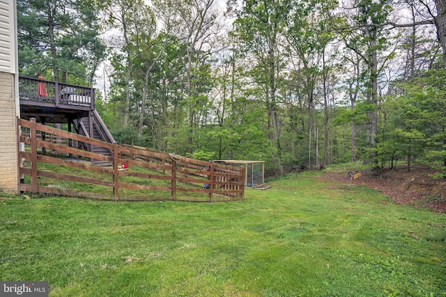 view of yard with stairway, a wooden deck, and fence