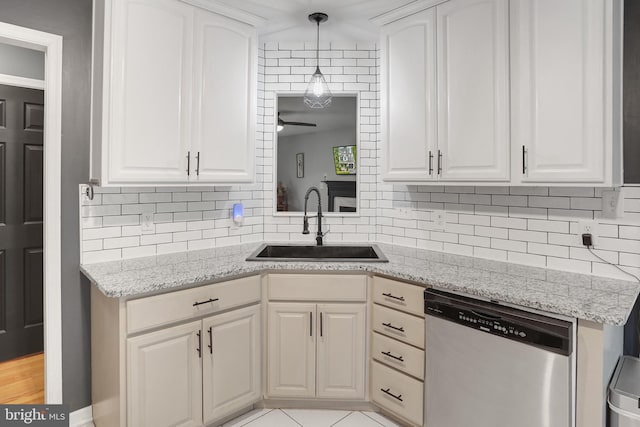 kitchen with a sink, stainless steel dishwasher, tasteful backsplash, and white cabinetry