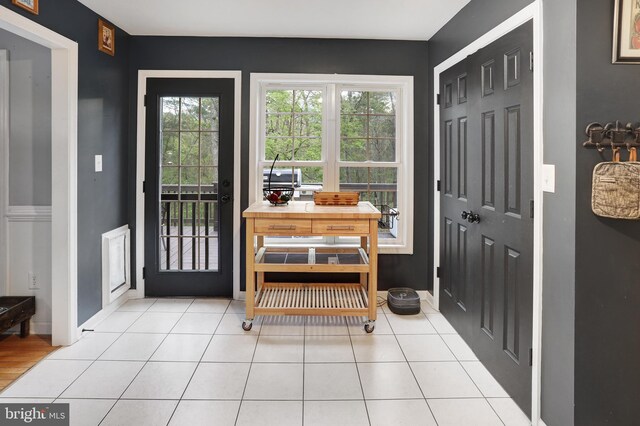 foyer featuring baseboards and light tile patterned flooring