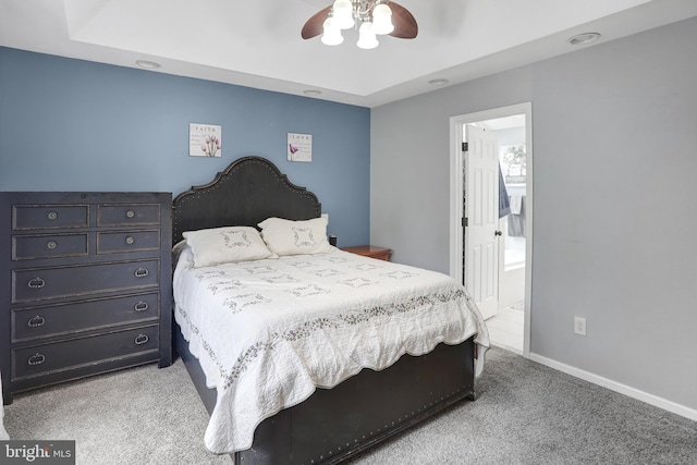 bedroom with a ceiling fan, baseboards, ensuite bath, and light colored carpet