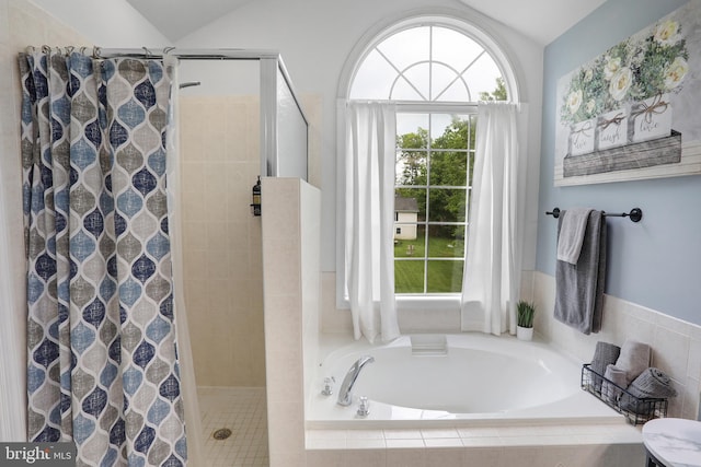 full bath with a bath, vaulted ceiling, and a shower stall