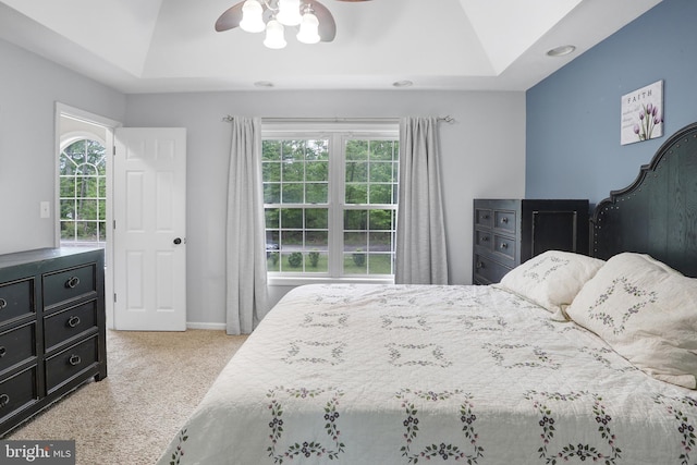 bedroom with a tray ceiling, carpet floors, and vaulted ceiling