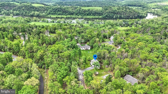 birds eye view of property featuring a water view and a view of trees