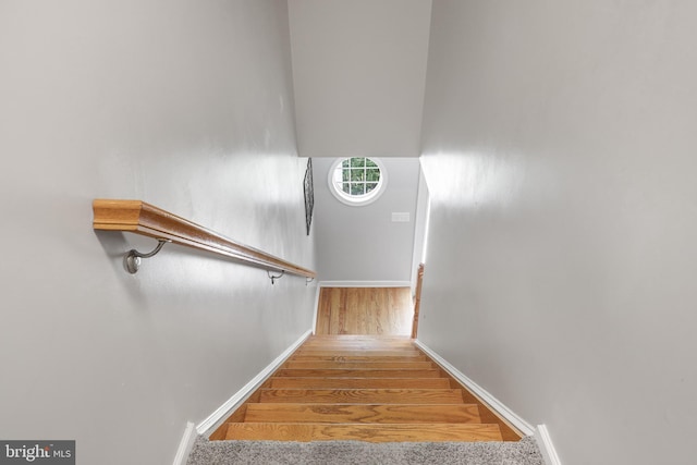 stairway featuring wood finished floors and baseboards