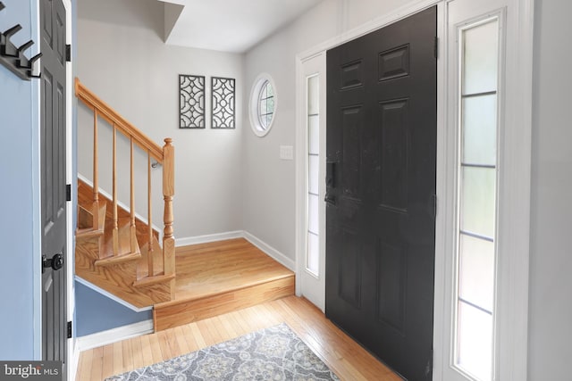 entrance foyer featuring stairway, wood-type flooring, and baseboards