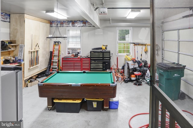 rec room featuring billiards, a garage, a healthy amount of sunlight, and concrete floors