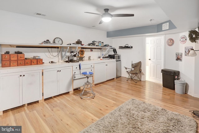 interior space with ceiling fan, light wood-style flooring, and visible vents