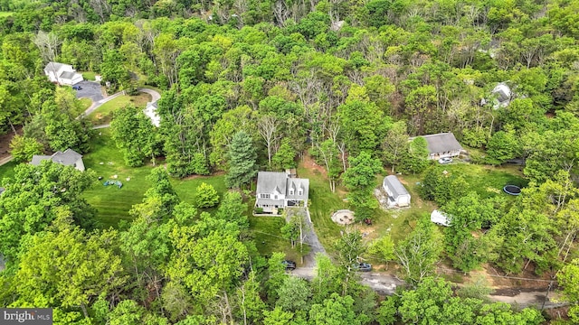 birds eye view of property featuring a forest view