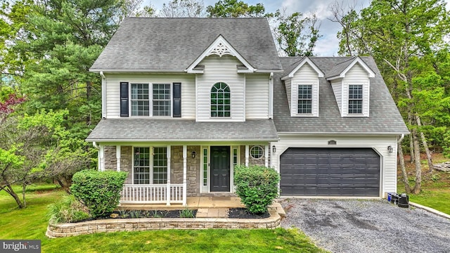view of front facade featuring driveway, an attached garage, a shingled roof, stone siding, and a porch