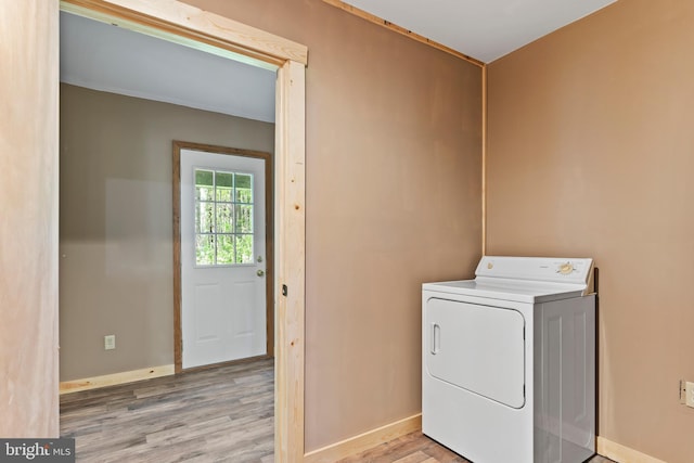 laundry area featuring washer / dryer, wood finished floors, and baseboards