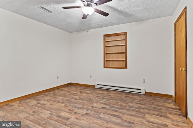 unfurnished bedroom featuring a baseboard radiator, a textured ceiling, wood finished floors, and baseboards