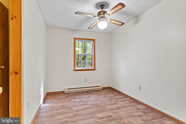 empty room with a baseboard heating unit, wood finished floors, ceiling fan, a textured ceiling, and baseboards