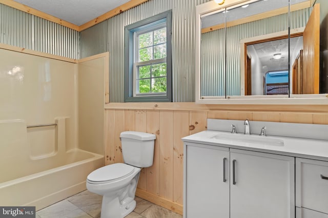 bathroom featuring toilet, vanity, wood walls, and bathtub / shower combination