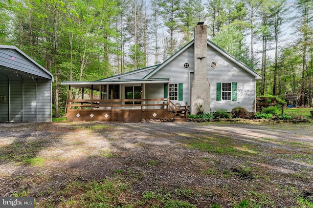 view of front of property with a chimney and covered porch