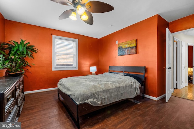 bedroom featuring wood finished floors, baseboards, and a ceiling fan