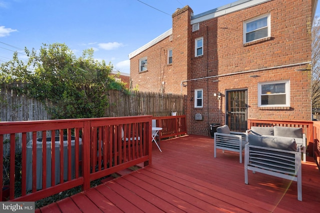 wooden deck with outdoor lounge area, a fenced backyard, and central AC