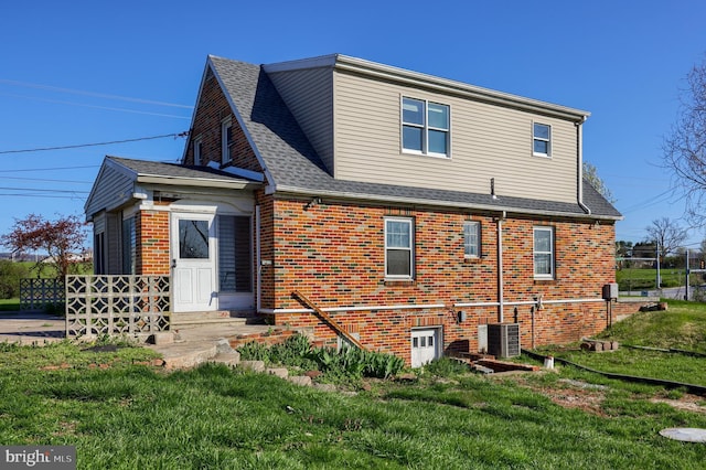 10 E Canal Rd, York, PA 17404 - back of house with a yard, a shingled roof, brick siding, and central AC