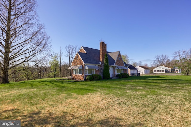 10 E Canal Rd, York, PA 17404 - view of side of property featuring a chimney, roof with shingles, and a lawn