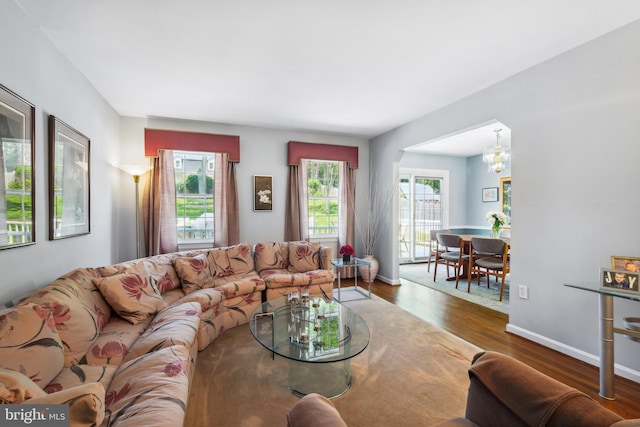 living room with a chandelier and wood finished floors