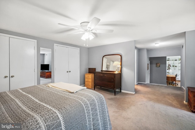 bedroom featuring two closets, light colored carpet, baseboards, and ceiling fan