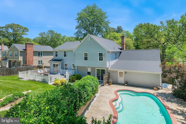 rear view of house featuring an outdoor pool, a patio area, and a wooden deck