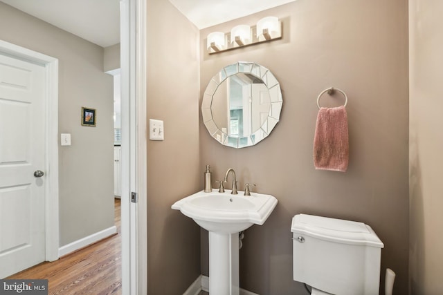 bathroom featuring wood finished floors, toilet, and baseboards