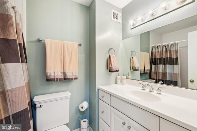 bathroom featuring toilet, a shower with shower curtain, and vanity