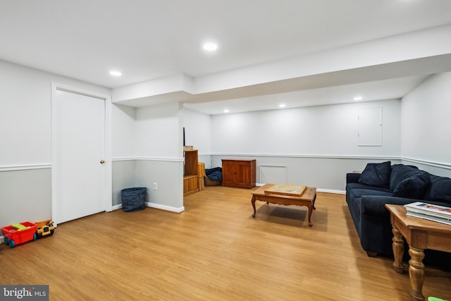 living area with light wood-type flooring, recessed lighting, and electric panel