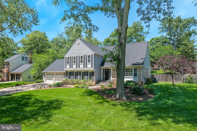 traditional-style home featuring driveway, a shingled roof, an attached garage, and brick siding