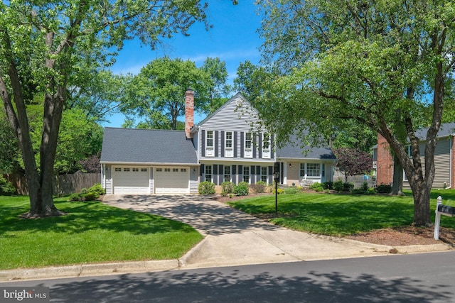 traditional-style home with an attached garage, a chimney, and driveway