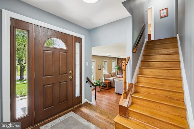 foyer entrance featuring stairway, wood finished floors, and baseboards