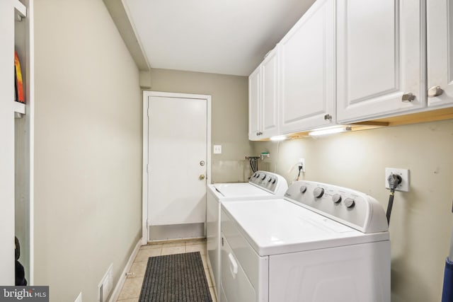 laundry area featuring cabinet space, washer and clothes dryer, light tile patterned floors, and baseboards
