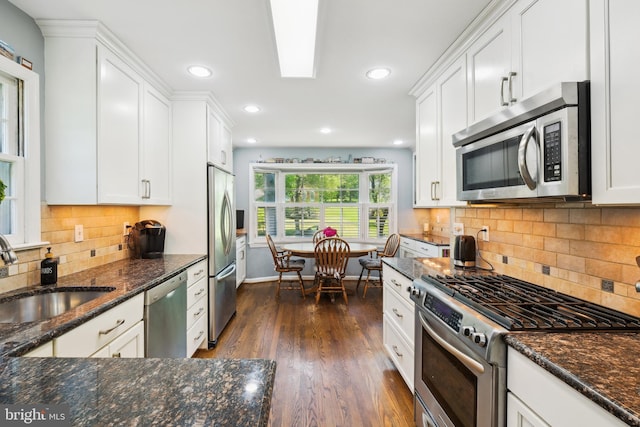 kitchen featuring appliances with stainless steel finishes, a sink, dark wood finished floors, white cabinetry, and recessed lighting