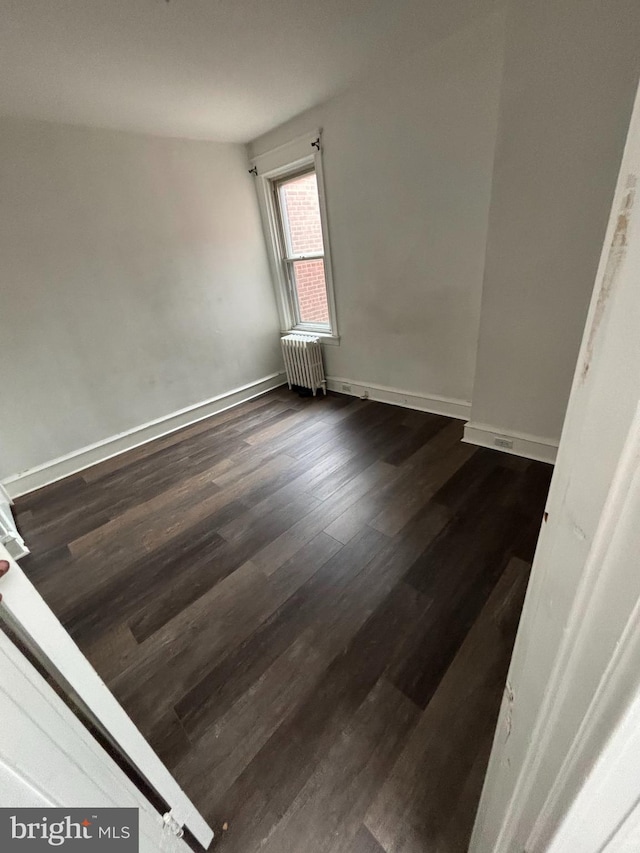 3313 Saint Vincent St, Philadelphia, PA 19149 - spare room with baseboards, radiator heating unit, and dark wood finished floors