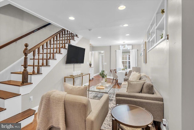 living area featuring wood finished floors, stairway, baseboards, and recessed lighting