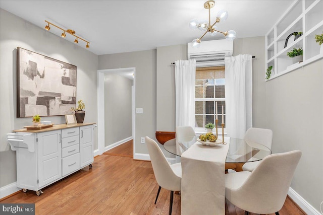 dining space featuring baseboards, an inviting chandelier, and light wood-type flooring
