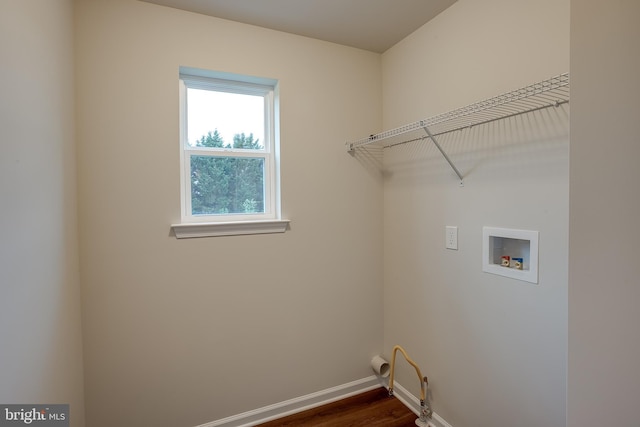 clothes washing area with baseboards, gas dryer hookup, hookup for a washing machine, dark wood-type flooring, and laundry area
