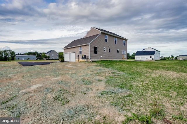 view of side of home featuring a garage and aphalt driveway