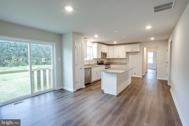 kitchen featuring baseboards, visible vents, a sink, white cabinets, and appliances with stainless steel finishes