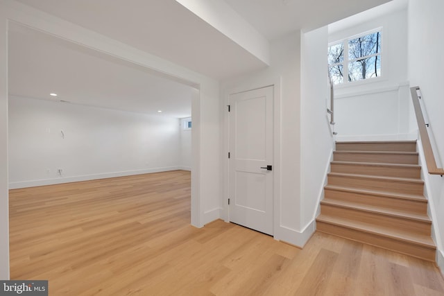 stairs with wood finished floors and baseboards