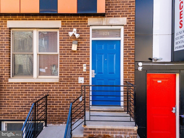 entrance to property featuring brick siding