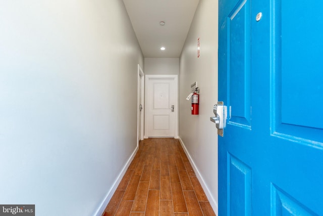 corridor with recessed lighting, baseboards, and dark wood finished floors