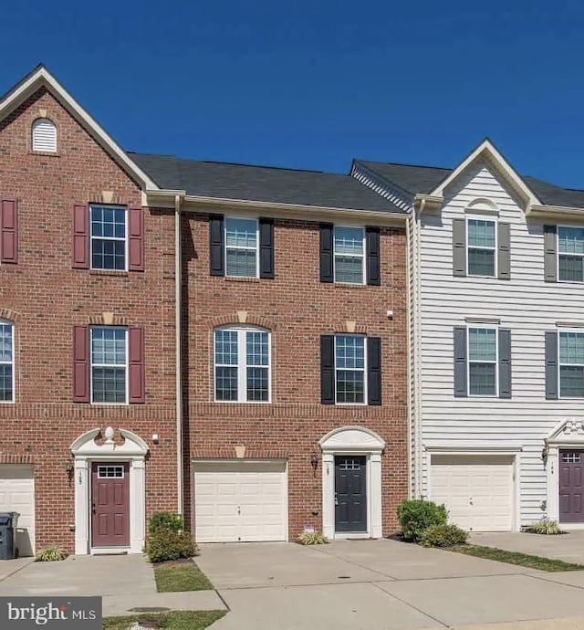 view of front of home with driveway, brick siding, and an attached garage