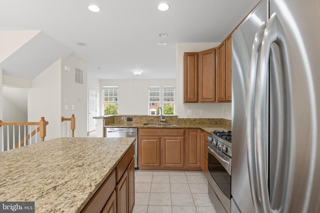 107 Bancroft Dr Unit 96, Fredericksburg, VA 22405 - kitchen with stainless steel appliances, a sink, light stone counters, recessed lighting, and brown cabinets