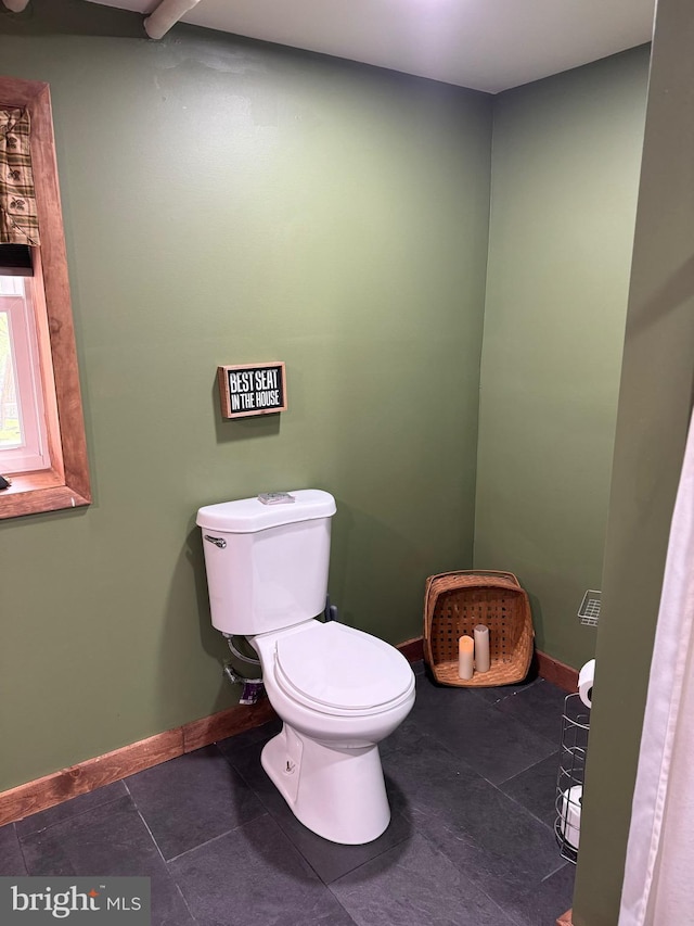 bathroom with baseboards and toilet