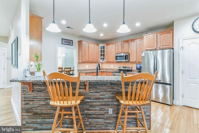 8200 Marshall Corner Rd, Pomfret, MD 20675 - kitchen featuring stainless steel appliances, light stone counters, a breakfast bar area, glass insert cabinets, and baseboards