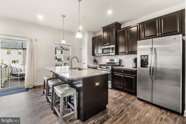 10732 Lamoka Ln, New Market, MD 21774 - kitchen with stainless steel appliances, a sink, dark wood-type flooring, an island with sink, and decorative backsplash