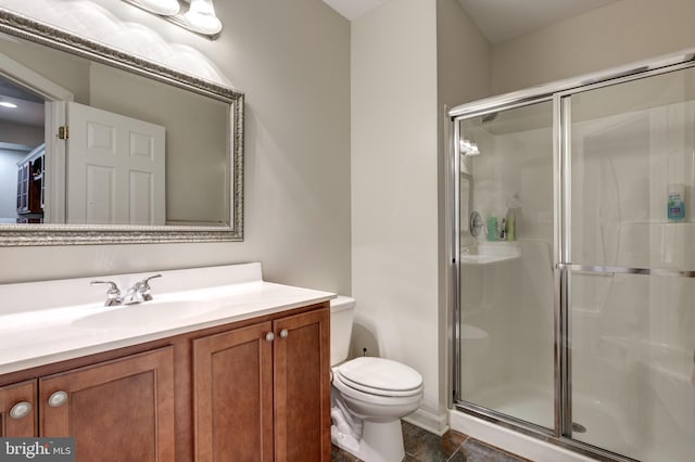 bathroom featuring a stall shower, toilet, and vanity