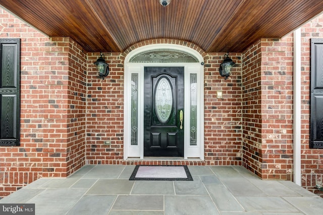 doorway to property featuring brick siding