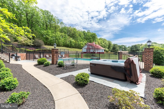 view of swimming pool with a hot tub, fence, and a patio area